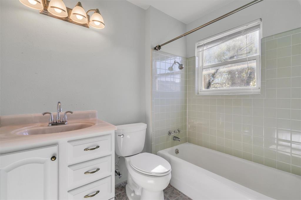 1832 Wonderlight Lane Dallas, TX 75228 - Photo 27 of 39 a bathroom with a granite countertop toilet a sink and a bathtub