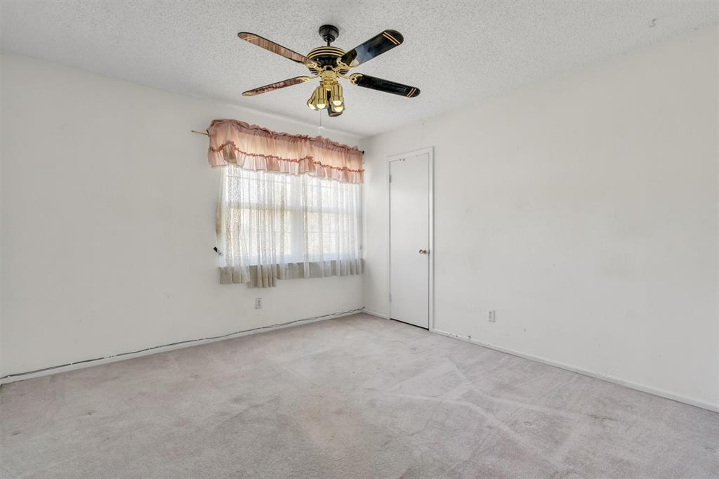 1832 Wonderlight Lane Dallas, TX 75228 - Photo 30 of 39 an empty room with windows and a ceiling fan