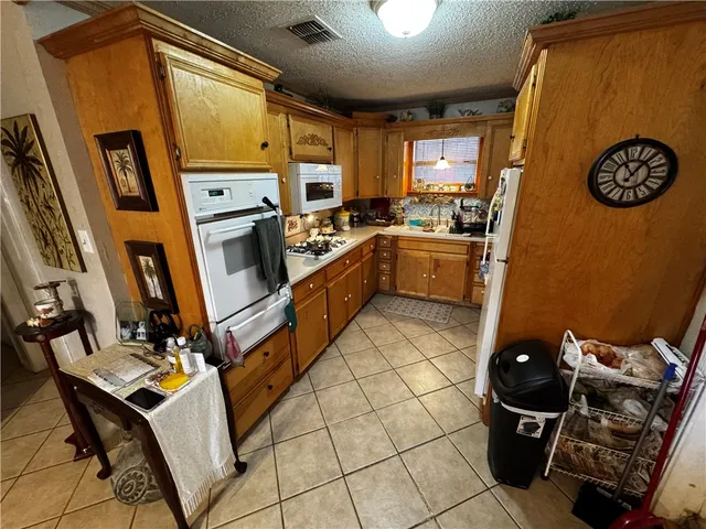 a kitchen with stainless steel appliances granite countertop a refrigerator and a stove top oven
