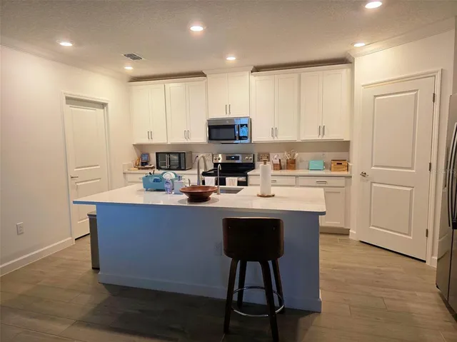 a kitchen with kitchen island a sink cabinets and wooden floor