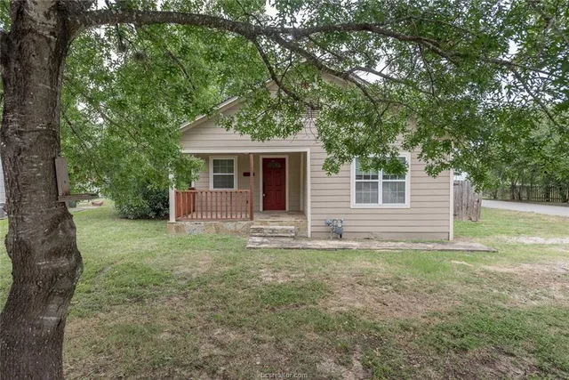 a view of a house with yard and a tree