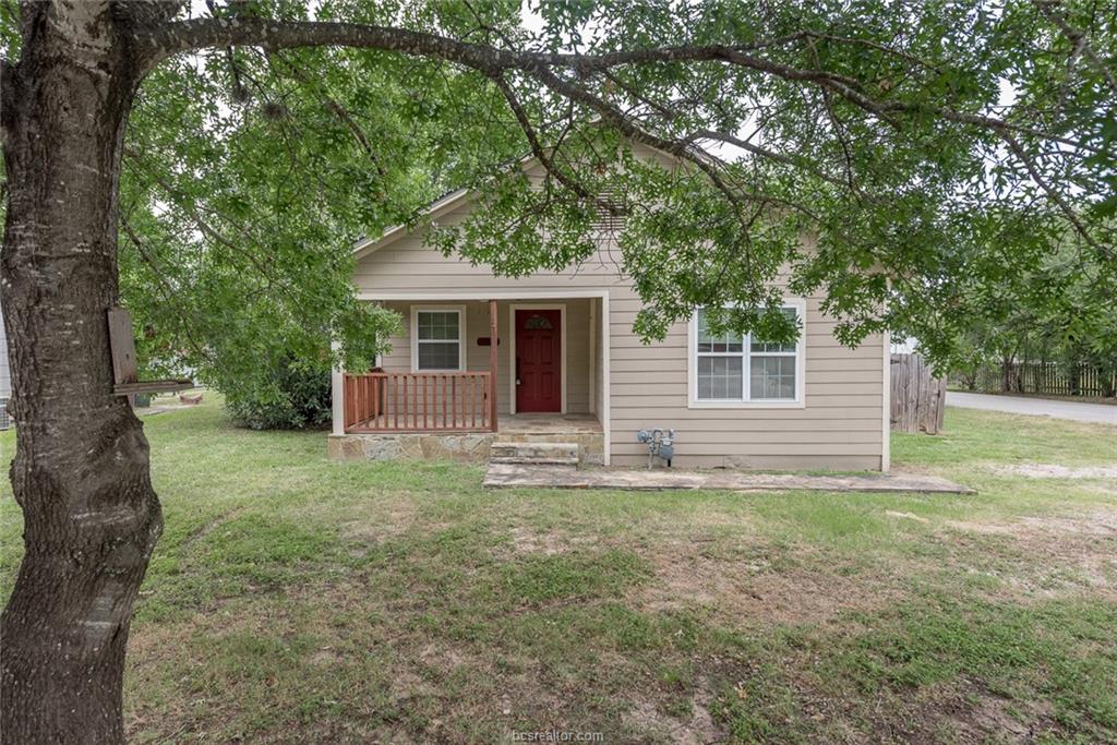 a view of a house with yard and a tree