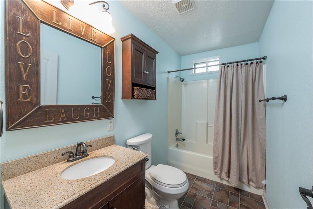 112 Sulphur Springs Road Bryan, TX 77801 - Photo 11 of 17 a bathroom with a granite countertop sink toilet a mirror and shower