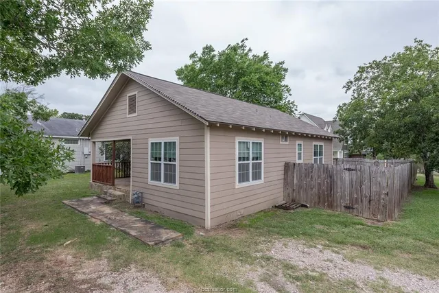 a view of a house with a yard and wooden fence