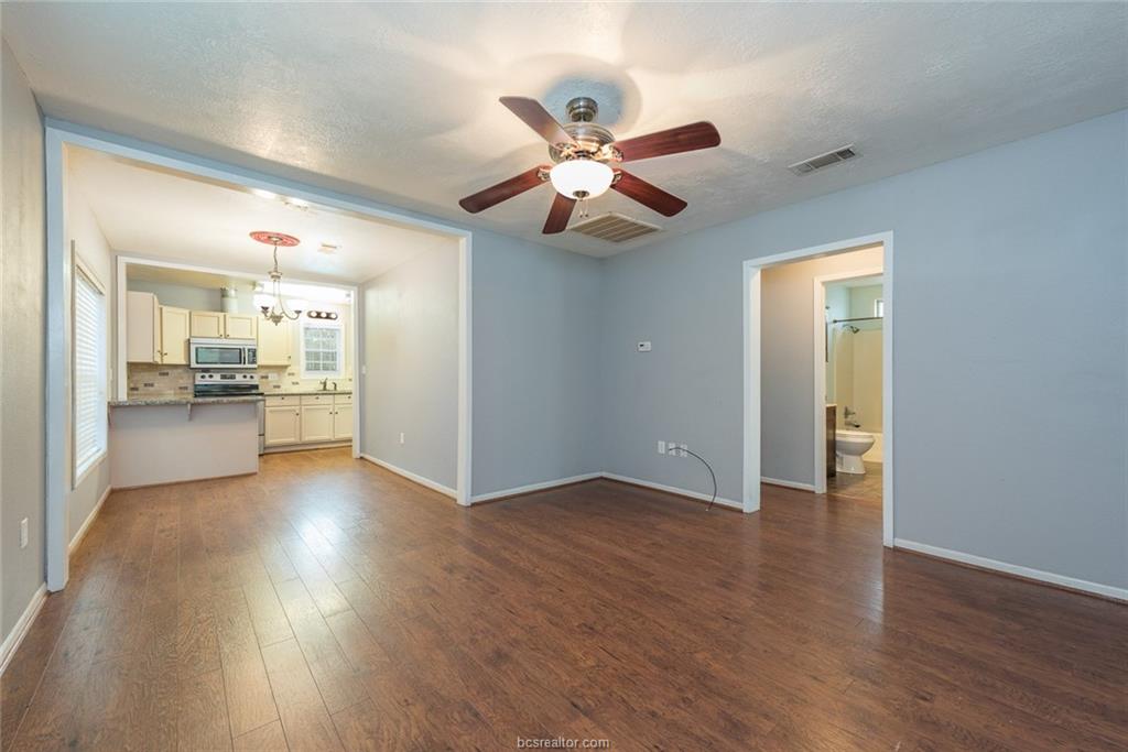 112 Sulphur Springs Road Bryan, TX 77801 - Photo 4 of 17 a view of an empty room and kitchen with wooden floor