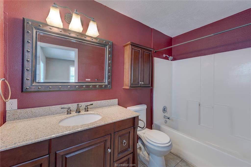 112 Sulphur Springs Road Bryan, TX 77801 - Photo 9 of 17 a bathroom with a granite countertop toilet sink and mirror