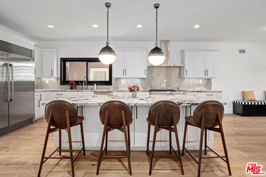 4811 Roma Court Marina del Rey, CA 90292 - Photo 18 of 57 a kitchen with kitchen island granite countertop a sink a center island stainless steel appliances and cabinets