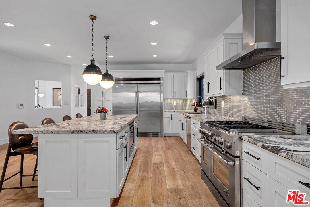 4811 Roma Court Marina del Rey, CA 90292 - Photo 21 of 57 a kitchen with stainless steel appliances granite countertop a sink a stove and a wooden floors