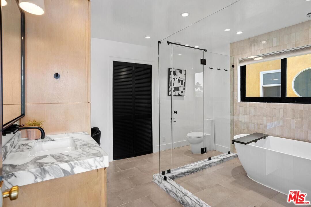 4811 Roma Court Marina del Rey, CA 90292 - Photo 29 of 57 a bathroom with a granite countertop tub shower sink and mirror