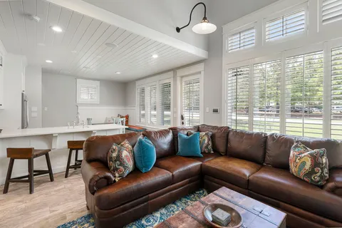 a living room with furniture wooden floor and a large window