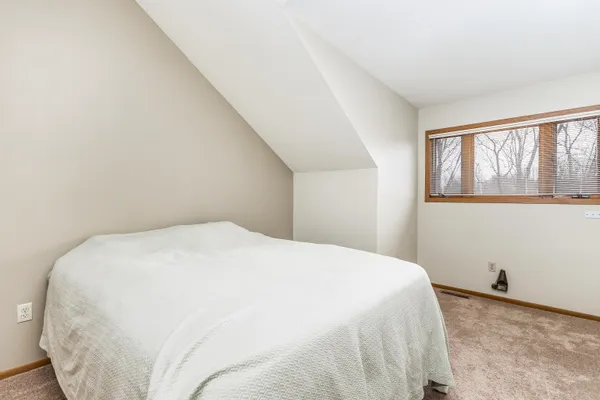 a large bed sitting in a bedroom next to a window