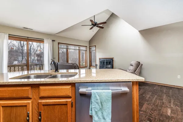 a dining hall with stainless steel appliances granite countertop a sink and a refrigerator