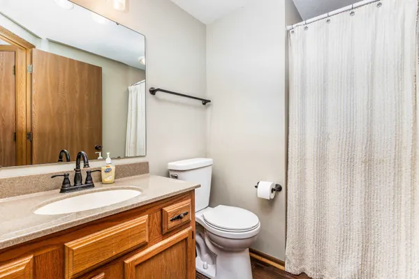 a bathroom with a granite countertop sink toilet and a mirror