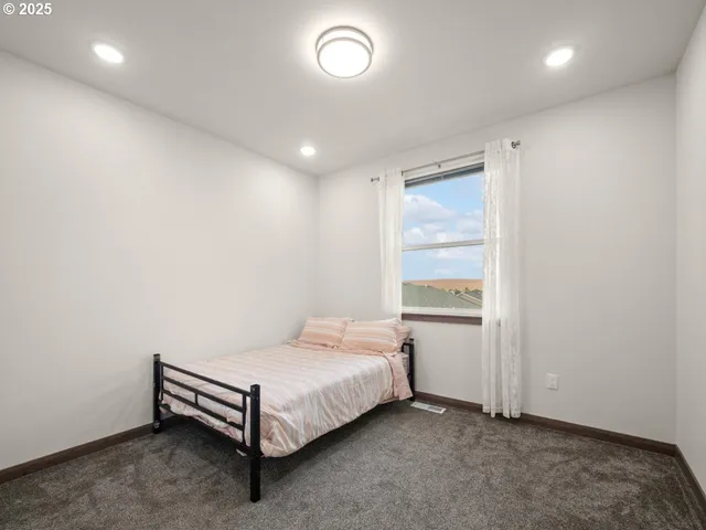 a bedroom with a bed and a painting