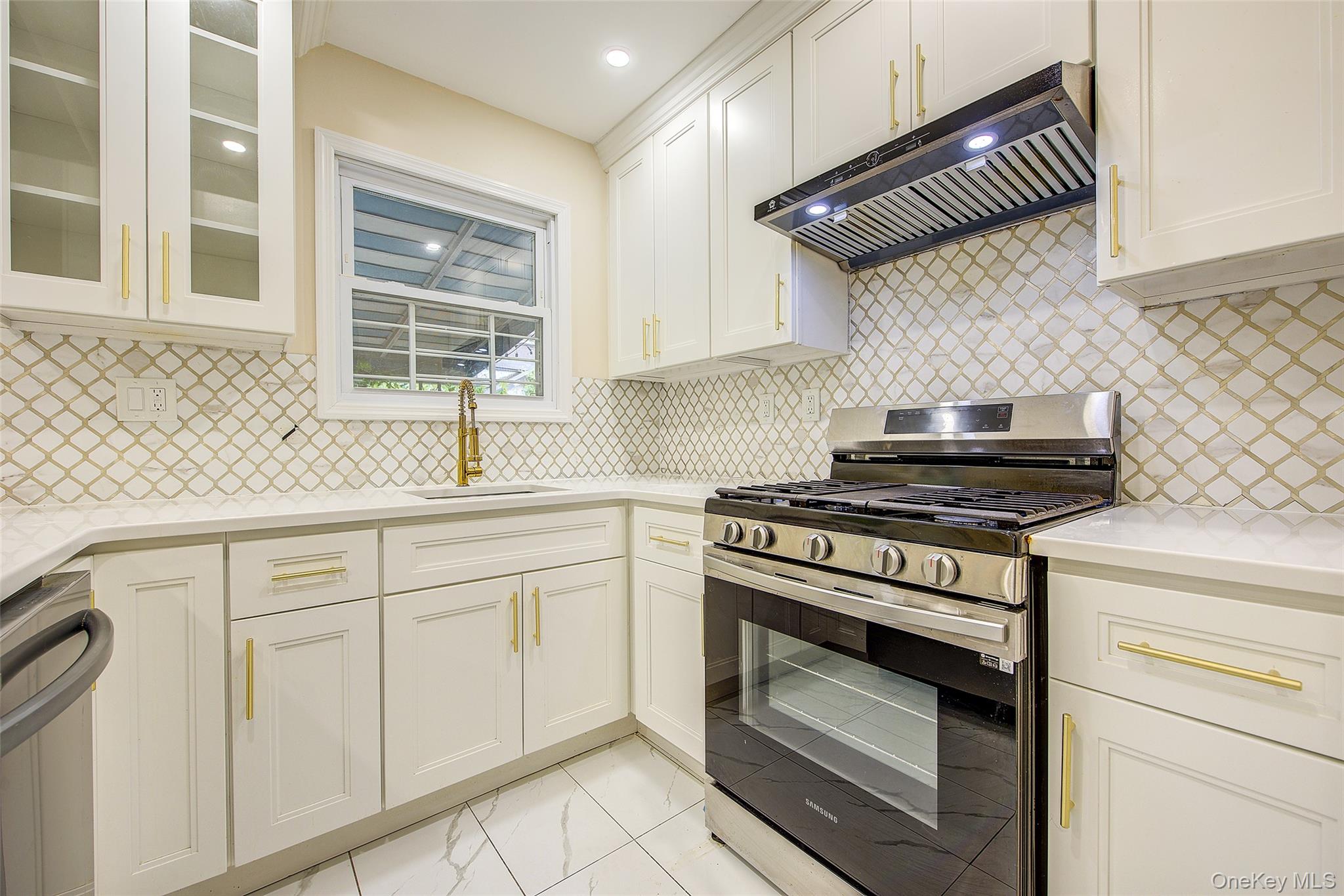 164-38 76th Road Queens, NY 11366 - Photo 11 of 44 a kitchen with granite countertop a stove sink and cabinets