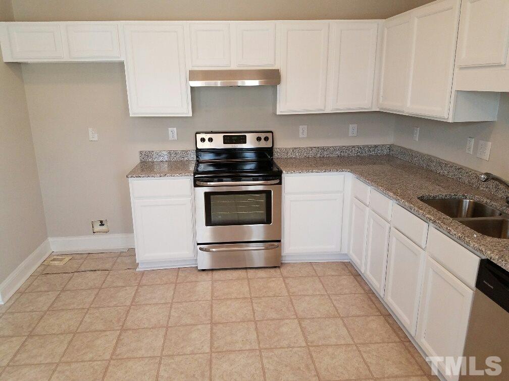 5021 Village Lawn Drive Raleigh, NC 27613 - Photo 5 of 9 a kitchen with a stove top oven and cabinets