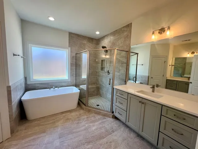 a bathroom with a double vanity sink tub and shower