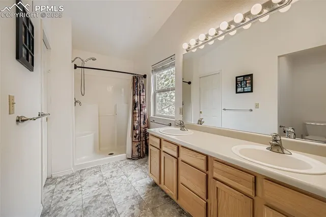 a spacious bathroom with a sink double vanity granite shower and a mirror