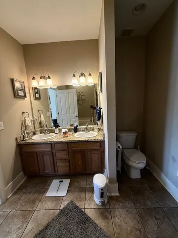 a bathroom with a double vanity sink and a toilet