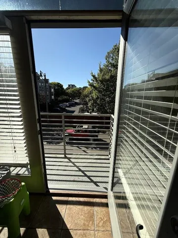 a view of a balcony with wooden floor and fence