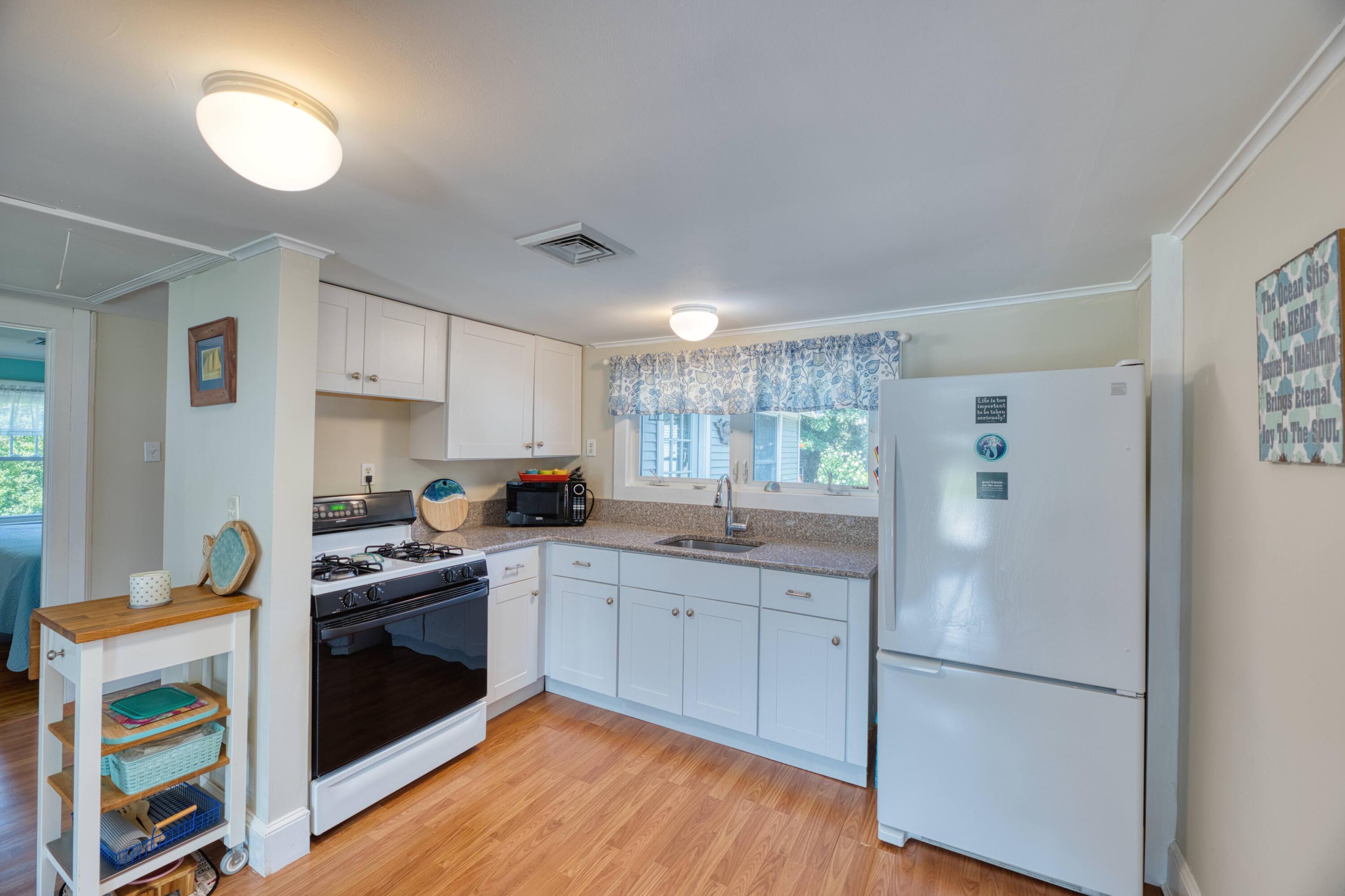 41 Bourne Neck Drive Buzzards Bay, MA 02532 - Photo 26 of 52 a kitchen with a sink a stove a refrigerator and white cabinets