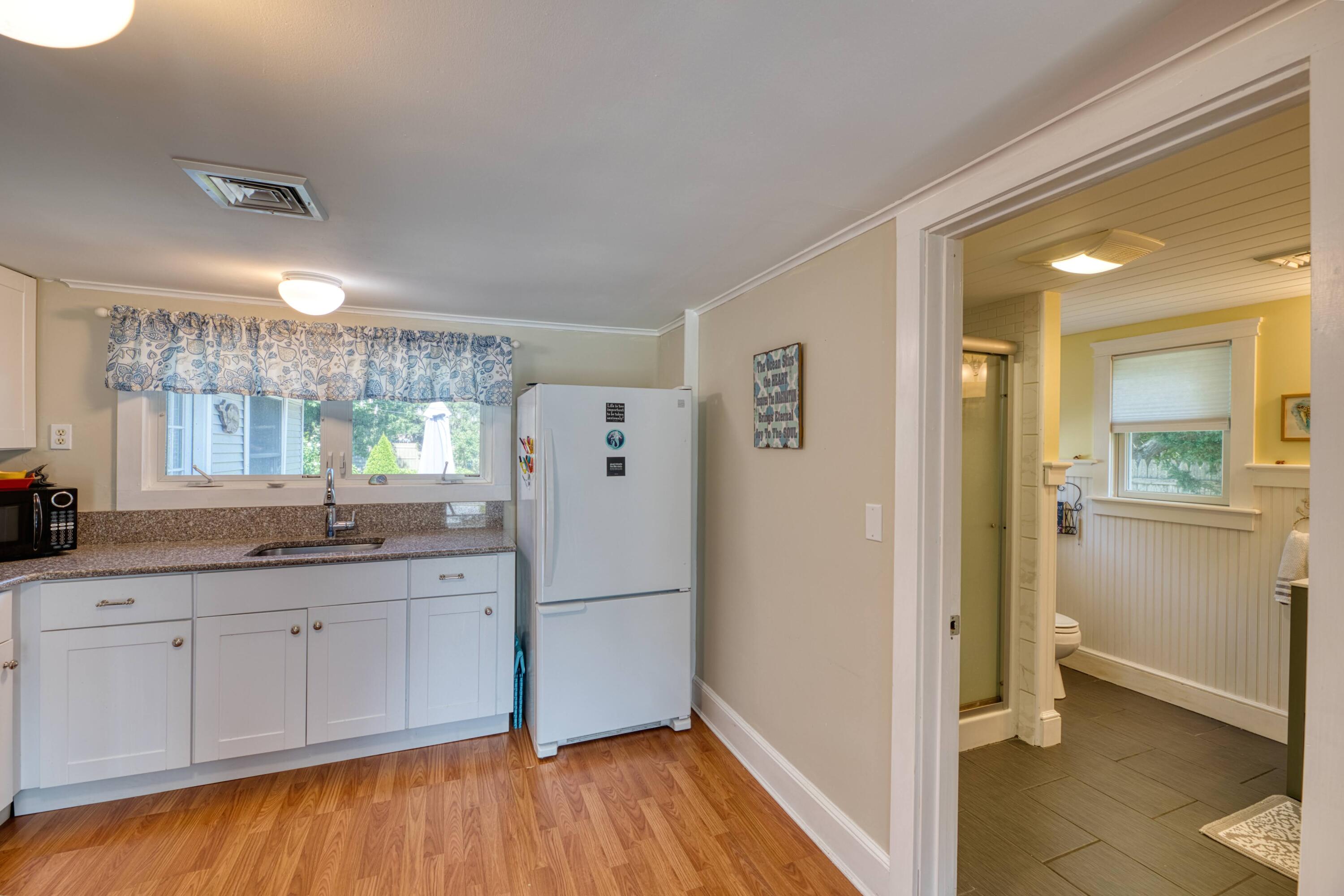 41 Bourne Neck Drive Buzzards Bay, MA 02532 - Photo 27 of 52 a kitchen with white cabinets and wooden floor