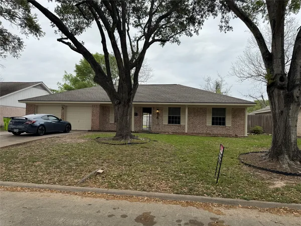 a front view of a house with a yard and trees