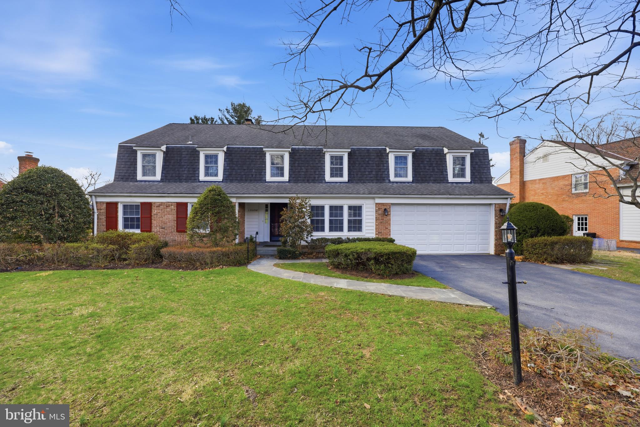 a front view of a house with yard and green space