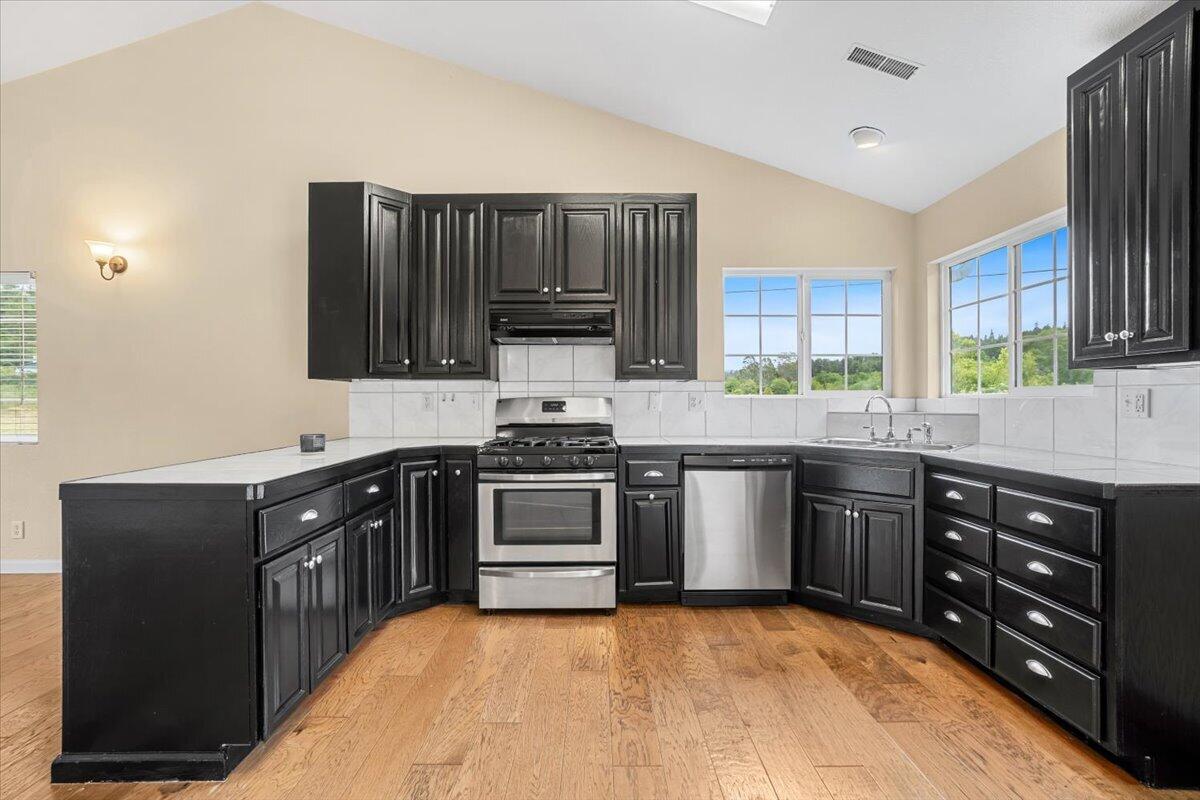 1196 Freshwater Road Eureka, CA 95503 - Photo 14 of 34 a kitchen with stainless steel appliances granite countertop a stove a sink dishwasher and a microwave oven with cabinets