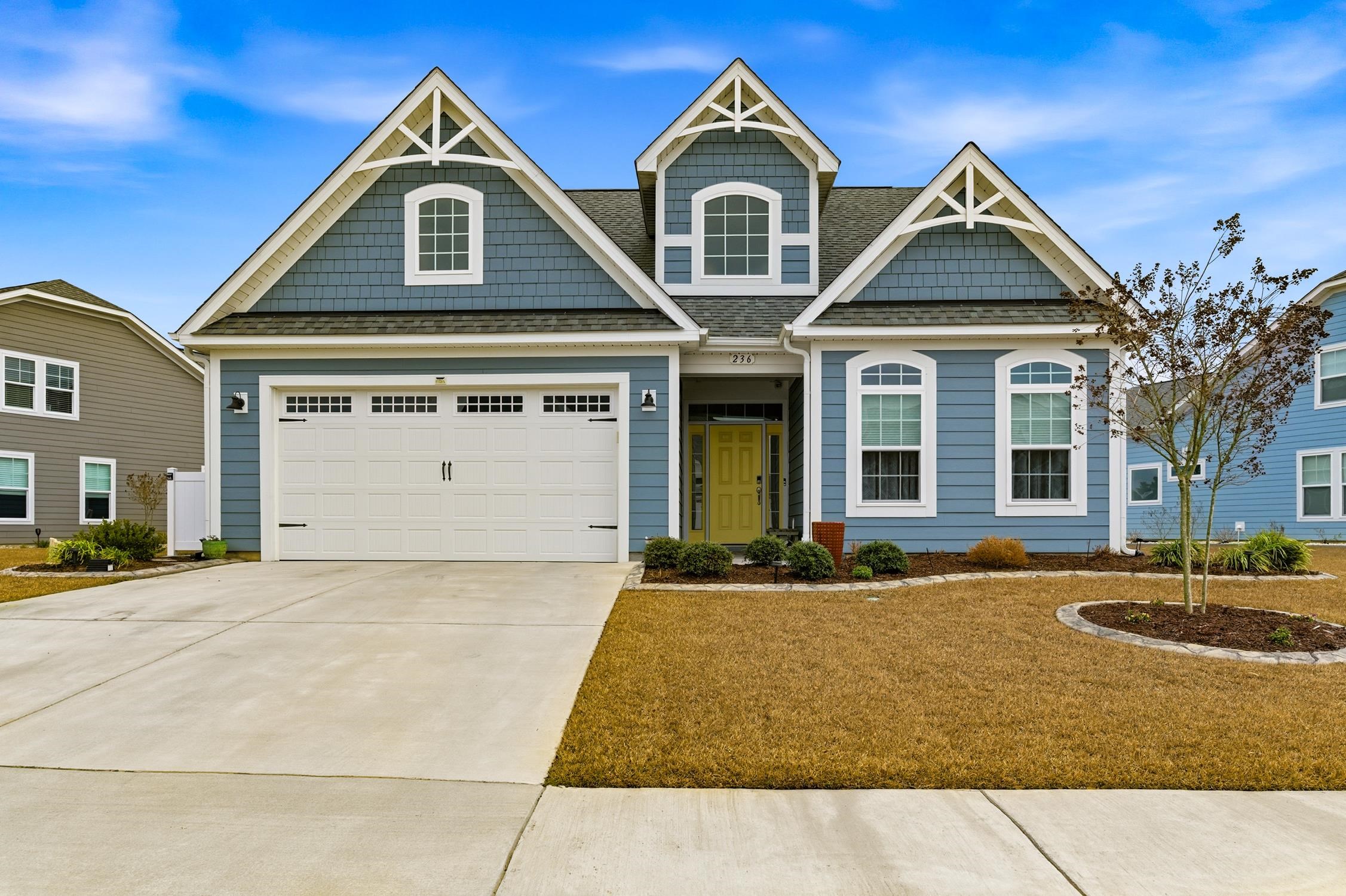 Craftsman house featuring roof with shingles, driveway, and a garage