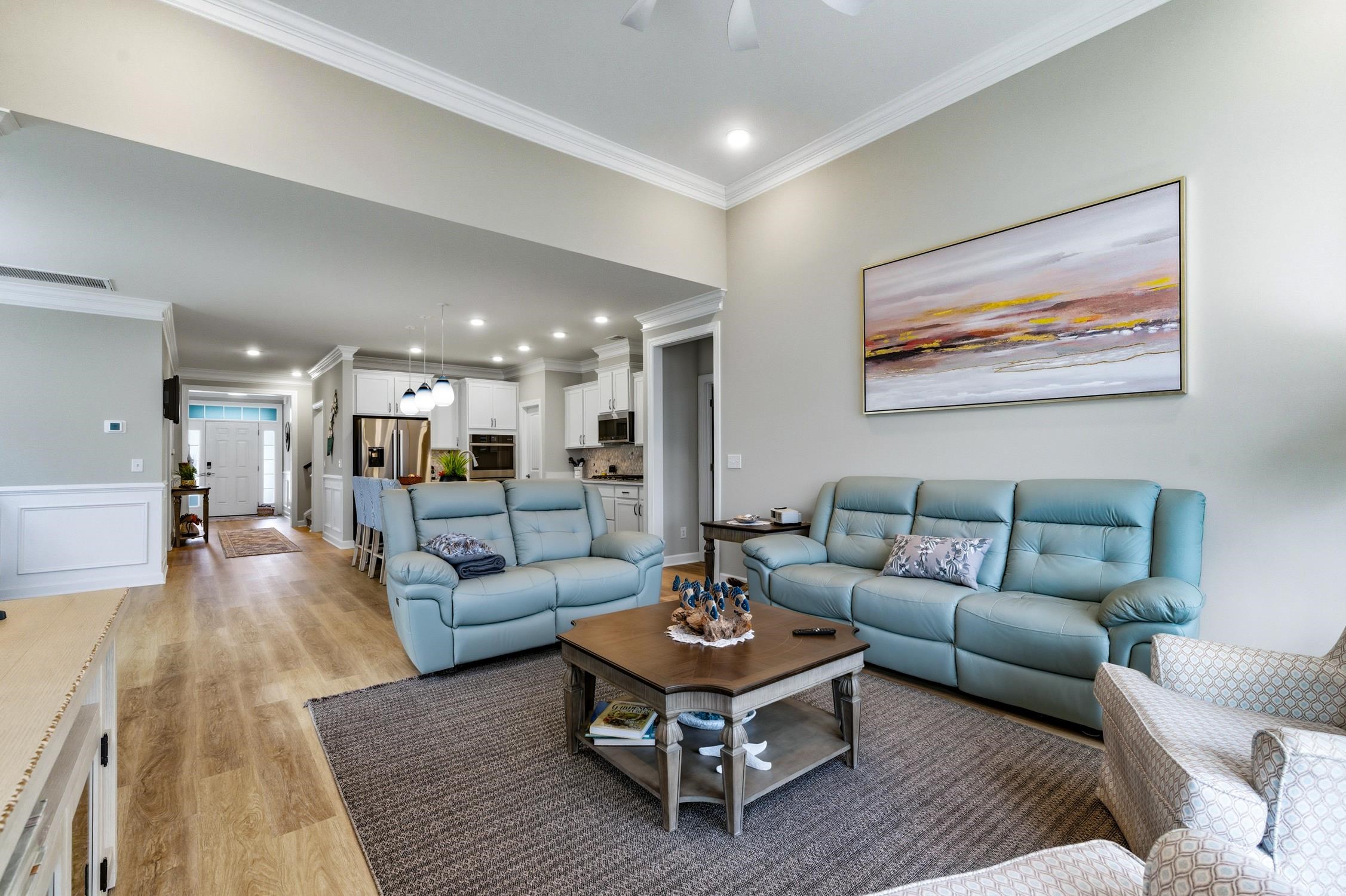 236 Bluestem Loop Little River, SC 29566 - Photo 11 of 40 Living room with crown molding, recessed lighting, a decorative wall, light wood-type flooring, and wainscoting