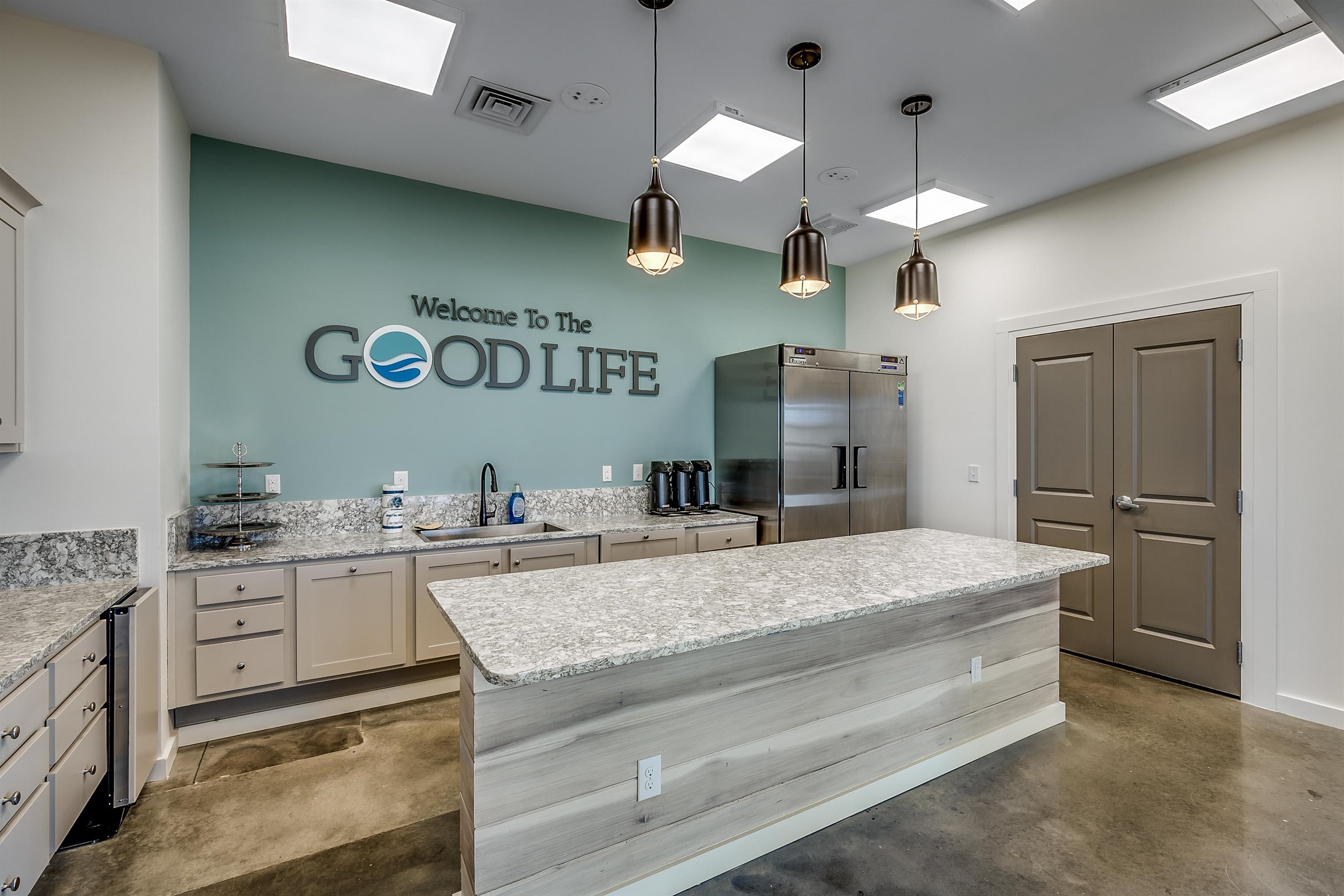 236 Bluestem Loop Little River, SC 29566 - Photo 36 of 40 Kitchen with decorative light fixtures, finished concrete flooring, a kitchen island, high end refrigerator, and light stone countertops