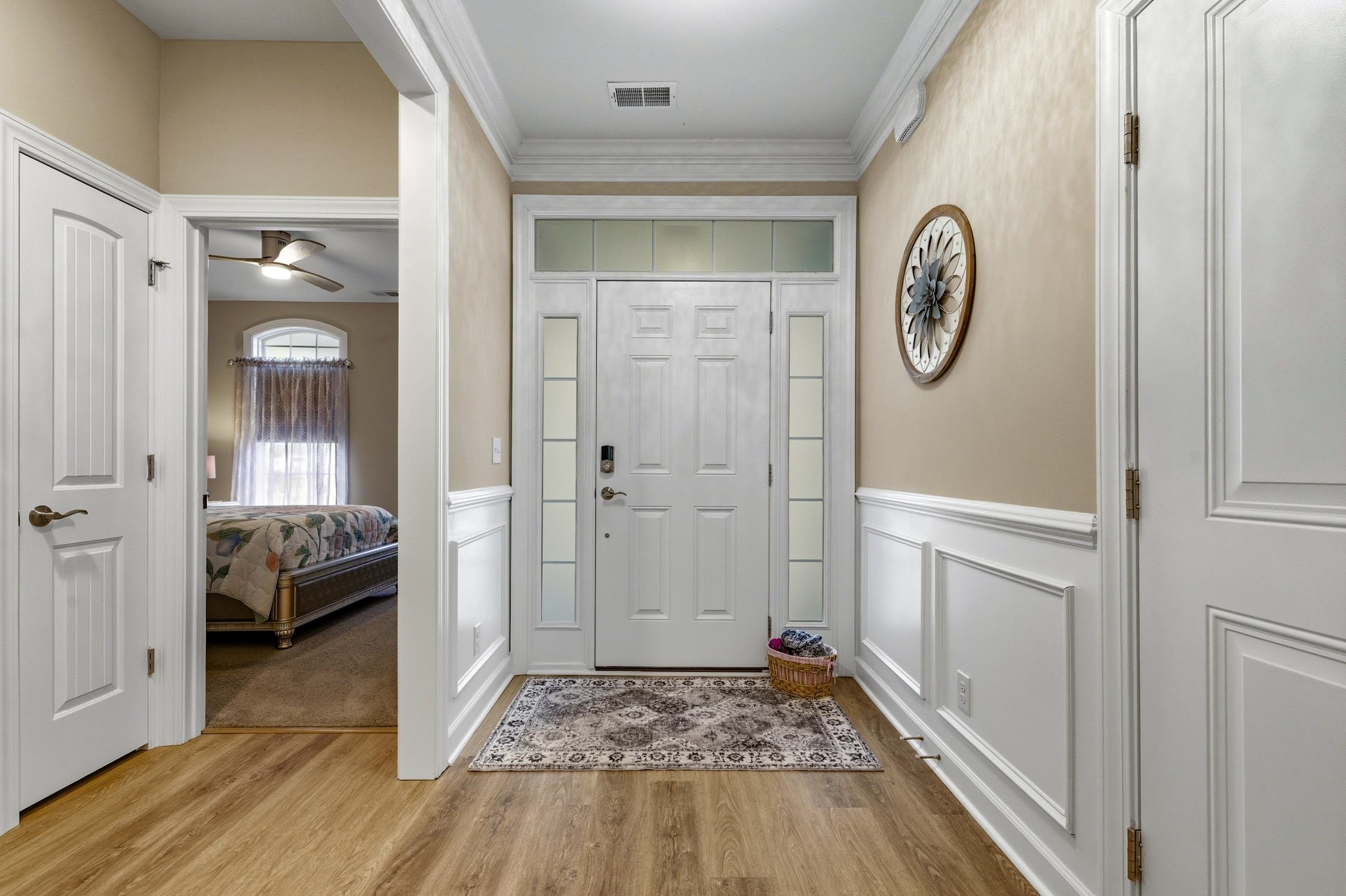 236 Bluestem Loop Little River, SC 29566 - Photo 7 of 40 Foyer featuring a decorative wall, light wood-style flooring, crown molding, ceiling fan, and a wainscoted wall