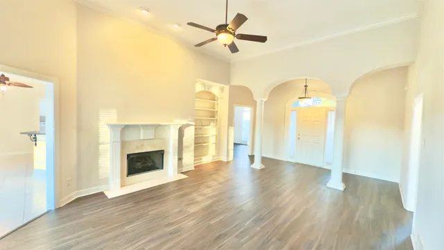 wooden floor fireplace and windows in an empty room