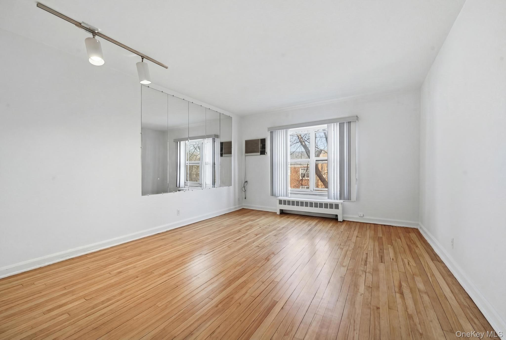 221 South Middle Neck Road, Unit F6 Great Neck, NY 11021 - Photo 16 of 16 a view of an empty room with window and wooden floor