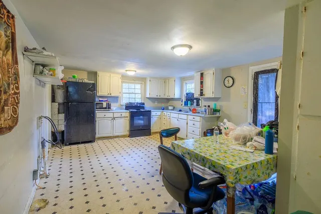 a kitchen with granite countertop kitchen island stainless steel appliances a sink and a refrigerator