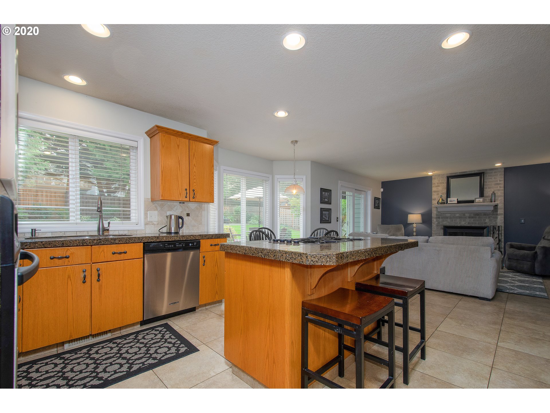 2415 Northeast 165th Street Ridgefield, WA 98642 - Photo 7 of 32 a kitchen with granite countertop dining table chairs cabinets and stainless steel appliances