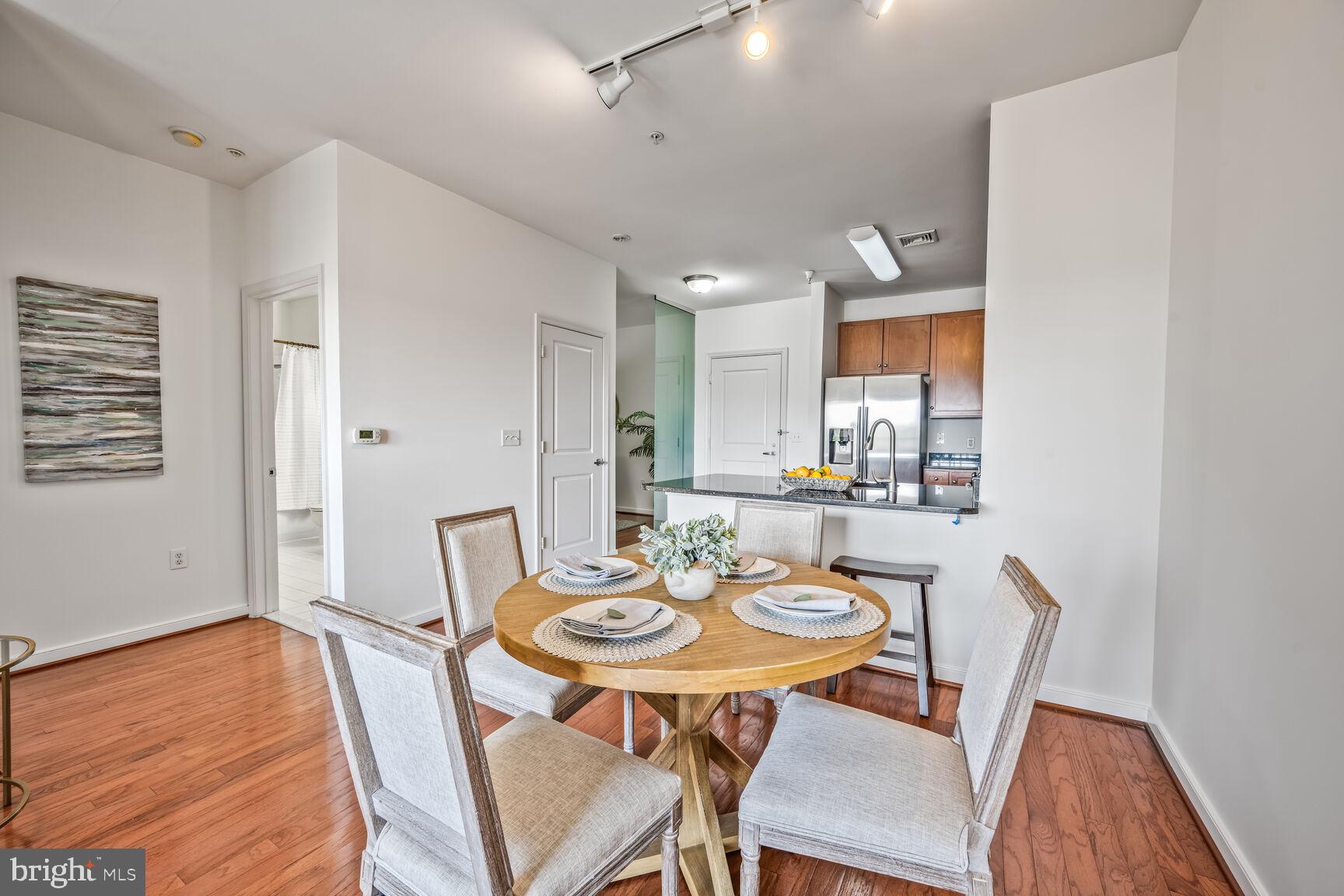 8045 Newell Street, Unit 516 Silver Spring, MD 20910 - Photo 11 of 33 a view of a dining room with furniture and wooden floor