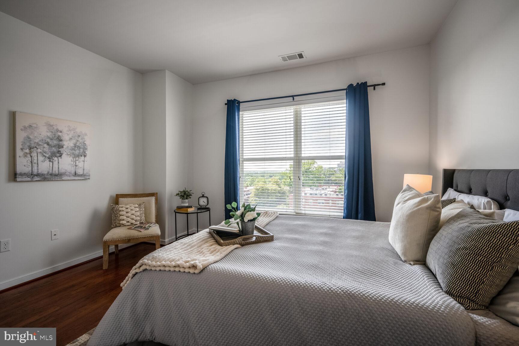 8045 Newell Street, Unit 516 Silver Spring, MD 20910 - Photo 16 of 33 a bedroom with a bed and wooden floor