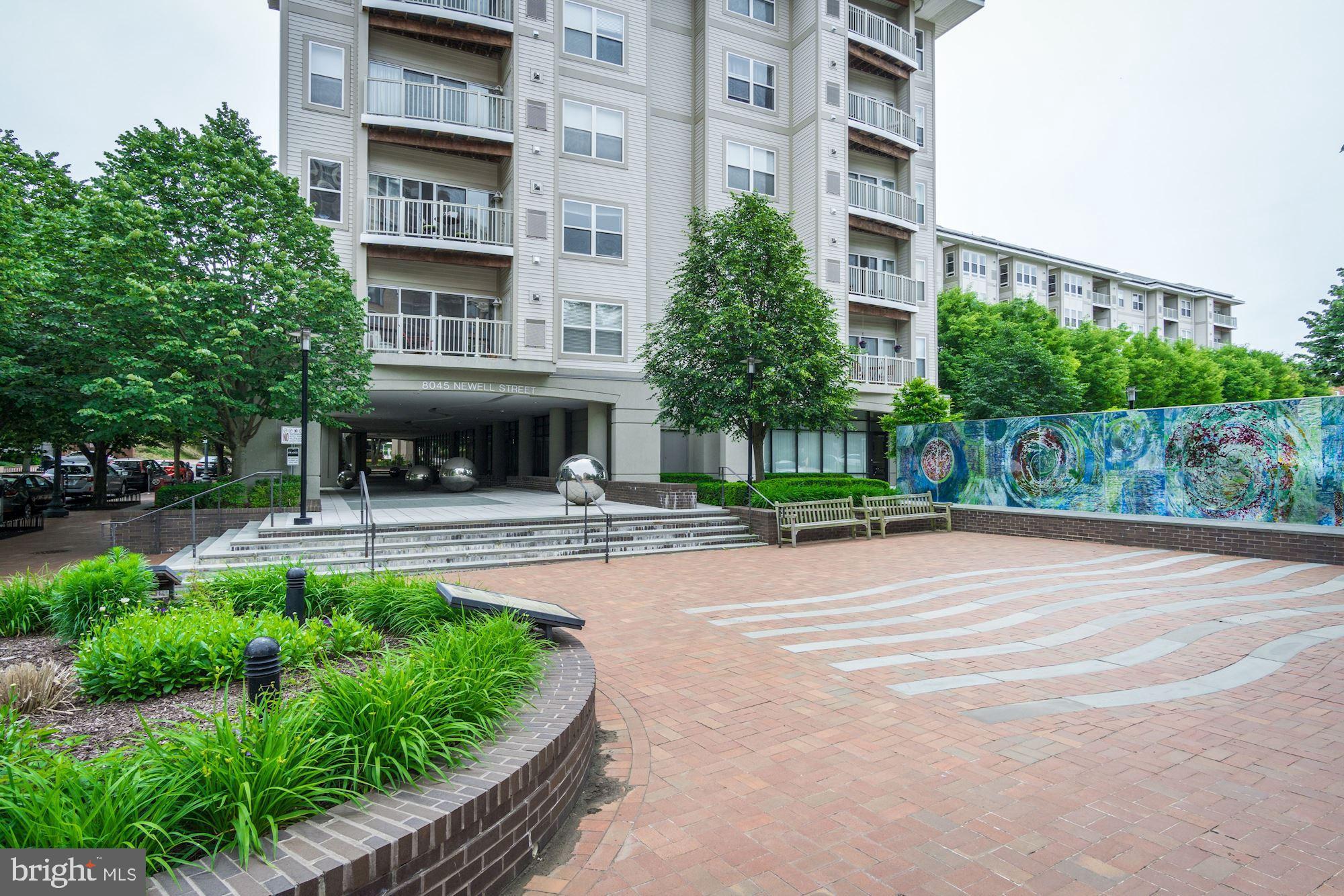 8045 Newell Street, Unit 516 Silver Spring, MD 20910 - Photo 2 of 33 a front view of a building with a garden and plants