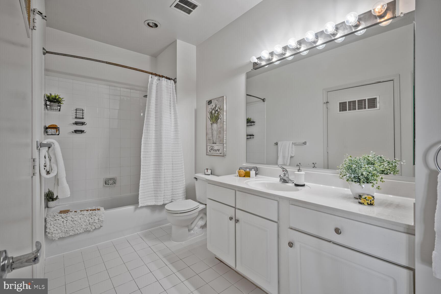 8045 Newell Street, Unit 516 Silver Spring, MD 20910 - Photo 22 of 33 a spacious bathroom with a double vanity sink mirror and toilet