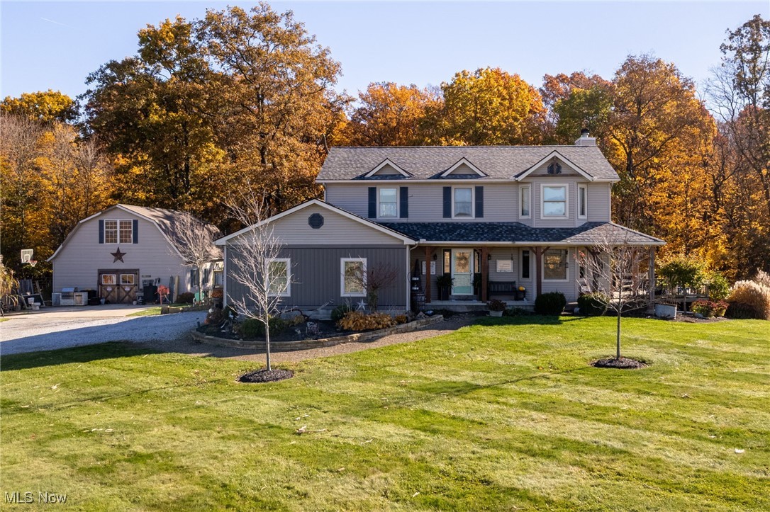 11827 Stratton Road West Salem, OH 44287 - Photo 1 of 47 View of front of property with a porch, a front lawn, a chimney, and view of wooded area