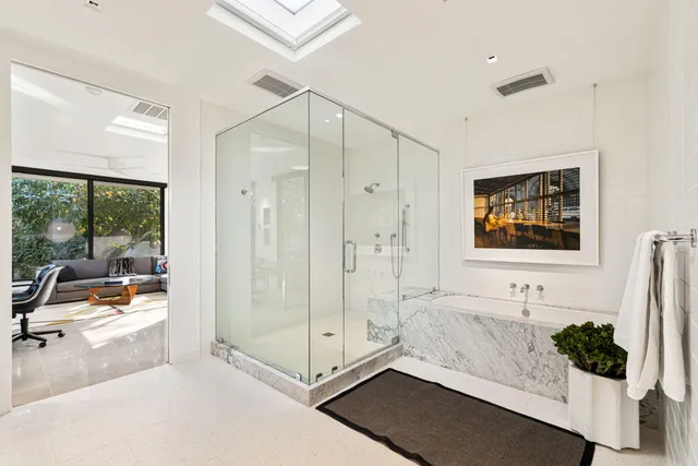 a bathroom with a sink a mirror and a potted plant