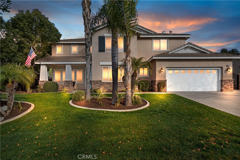 a front view of a house with a yard garage and fountain