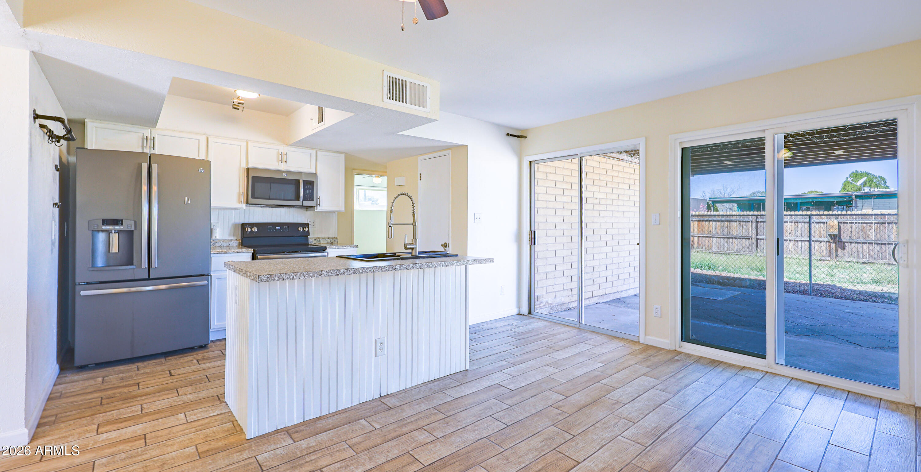 520 South 3rd Street Sierra Vista, AZ 85635 - Photo 6 of 28 a kitchen with kitchen island wooden floors appliances and cabinets