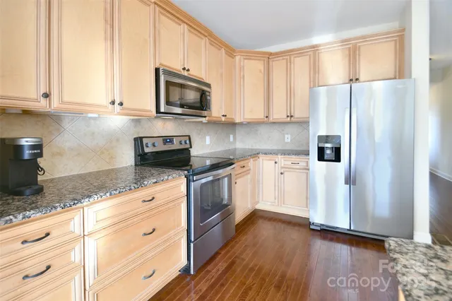 a kitchen with granite countertop white cabinets and white appliances