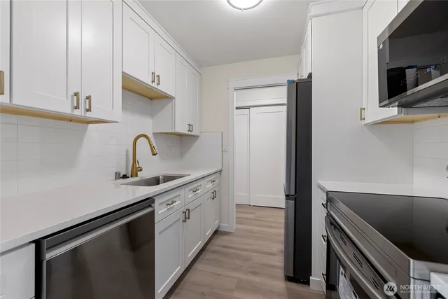 a kitchen with stainless steel appliances a sink stove and cabinets