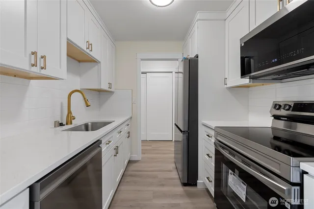 a kitchen with stainless steel appliances a sink stove and refrigerator