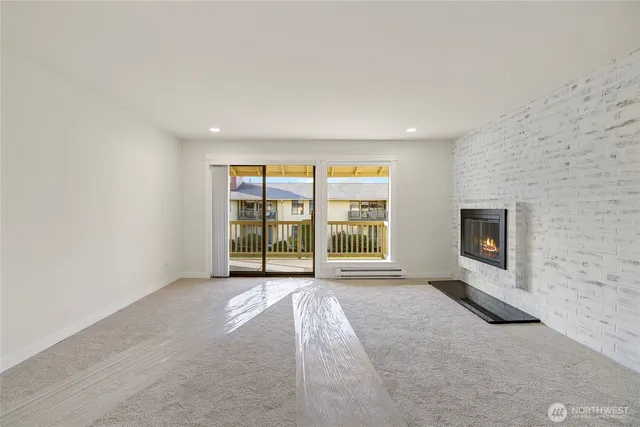 an empty room with a fireplace and windows