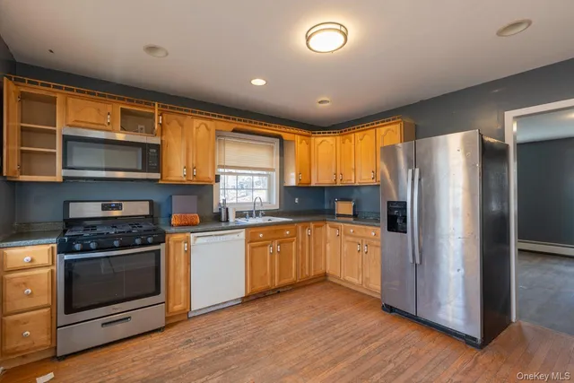 a kitchen with stainless steel appliances granite countertop a stove top oven a refrigerator and a microwave